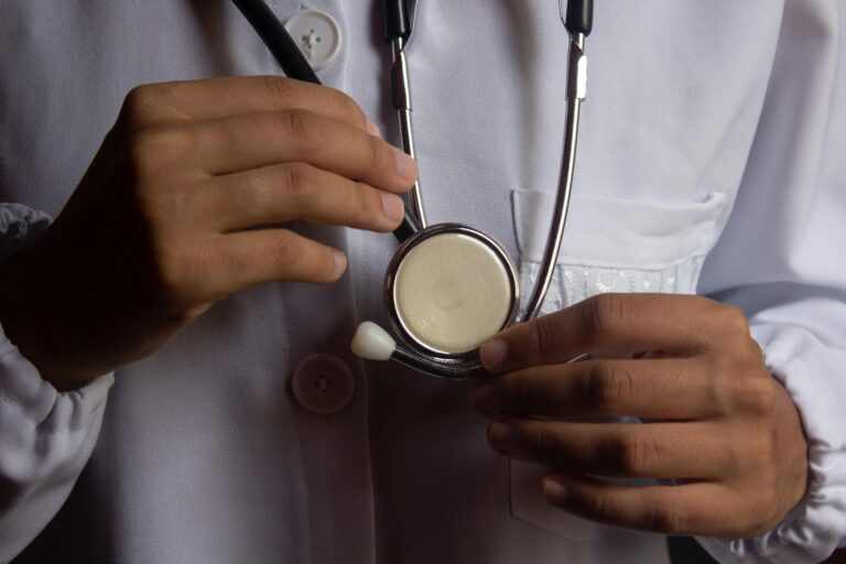 A close-up image showing a doctor holding a stethoscope, symbolizing healthcare and medical practice.