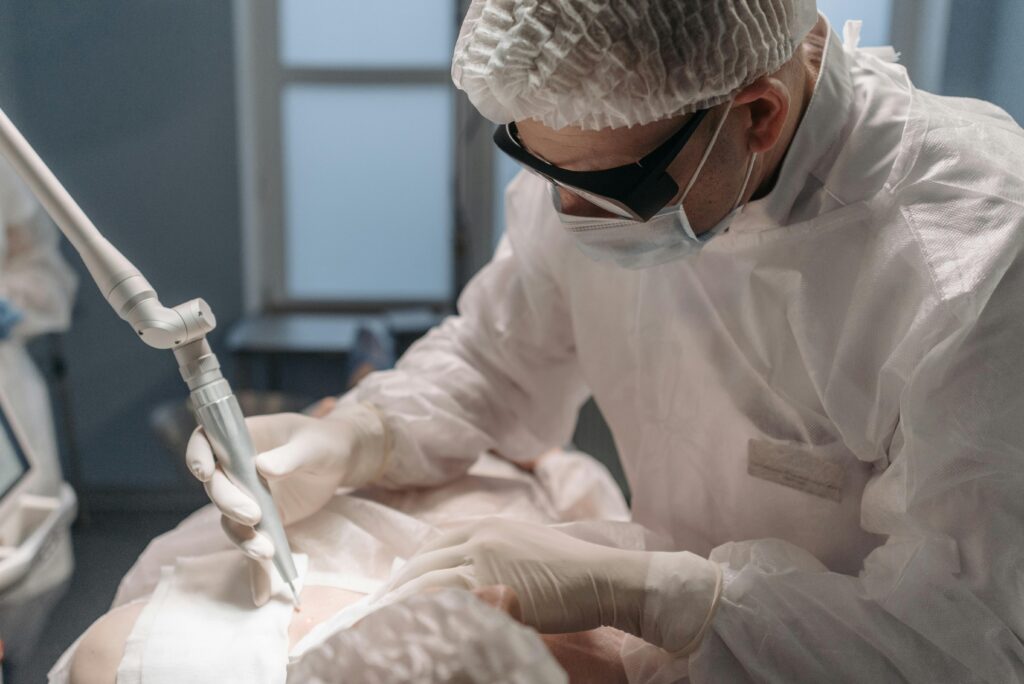 A focused surgeon performs laser surgery in a sterile operating room, emphasizing precision and care.